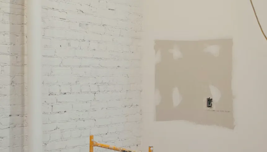 Pintor aplicando acabado en una pared interior